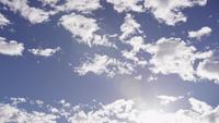 Tidsförlopp av altocumulus moln som rör sig på blå himmel och solljusfläckar i botten av scenen i 4K