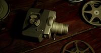 Korte panning shot van vier filmrollen, een blik en een oude camera op een tafel in 4K
