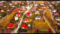 Vista de zánganos en casas en un pueblo - efecto de cambio de inclinación en 4K