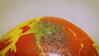 Glitter op oranje en gele verf