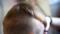 Kinderhaarschnitt im Salon. Kleiner junge friseur Kinderhaar-Styling. Friseur, der stilvolle Frisur für kleinen Jungen macht