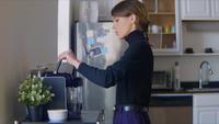 Ung kvinna gör sig en espresso i sitt kök