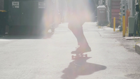 Homem barbudo no beco aproximando e fazendo truques de skate