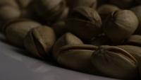 Cinematic, rotating shot of pistachios on a white surface - PISTACHIOS 043