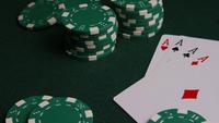 Roterande skott av pokerkort och pokerchips på en grön filtyta - POKER 005