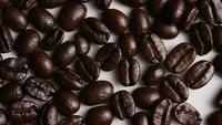 Rotativa tiro de deliciosos grãos de café torrados em uma superfície branca - FEIJÕES DE CAFÉ 031