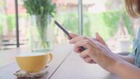 Blogger fêmea que fotografa o copo de chá verde no café com seu telefone.