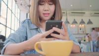 Blogger fêmea que fotografa o copo de chá verde no café com seu telefone.