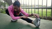 Sportswear da forma da menina do esporte da aptidão que faz o exercício da aptidão da ioga na rua. Mulher asiática nova apta que faz o exercício do treinamento na manhã. Mulher asiática feliz nova que estica no parque após o exercício running.