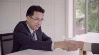 Câmera lenta - Smart empresários bonitos apertando as mãos depois de assinar um contrato de casa.