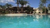 Sunny Hotel Resort med lyxig blå pool, vattenrutschbanor, palmer, parasoller och solstolar i Egypten. Rik semester på den soliga resorten. Tomt egyptiskt hotell med pool
