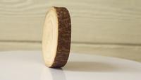 Un soporte de madera gira contra una pared de madera blanca.