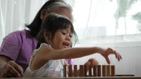 Mormor och barnbarn lekte med Jenga-block