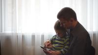 Vater und Sohn, die Spiel am Handy spielen