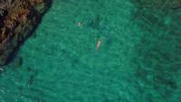 Top down view of a girl swimming in the sea in 4K