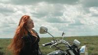Biker Woman on Top of Grassy Hill