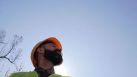 Bauleiter in einem Helm, der draußen steht