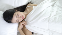 Jeune femme asiatique endormie sur le lit.